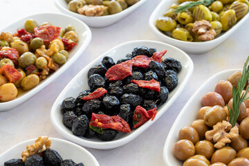 varieties of olives on the plate on a white background