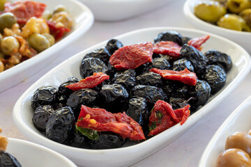 varieties of olives on the plate on a white background