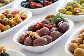 varieties of olives on the plate on a white background