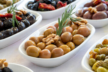 varieties of olives on the plate on a white background
