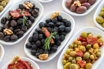 varieties of olives on the plate on a white background