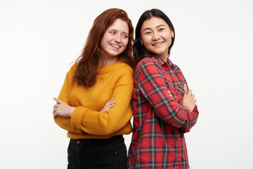 People and lifestyle concept. Two happy girls. Wearing yellow sweater and checkered shirt. Standing...