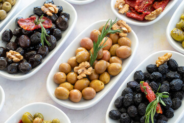 varieties of olives on the plate on a white background