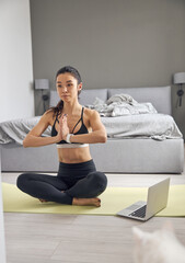 Happy beautiful asian woman is doing morning sport exercises at cozy bedroom