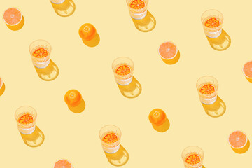 Creative pattern made with sliced grapefruit, blood orange and glass with lemonade or water on...