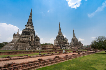 Fototapeta premium three ancient pagodas (chedies) ruins of old Siam capital Ayutthaya at Wat Phra Si Sanphet temple and walk way, famous place for travelling in Phra Nakhon Si Ayutthaya Province, Thailand 