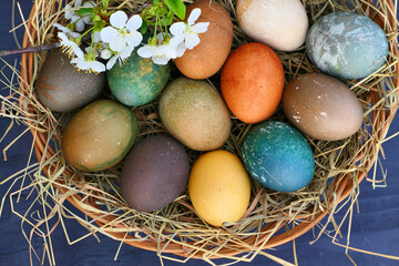 Easter eggs in basket nest. Natural coloring of Easter eggs.