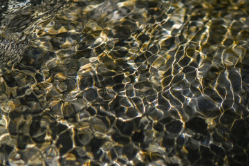 Closeup of restless surface of a mountain stream. Abstract water surface. Macro photography.