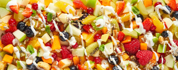 Background of appetizing assorted fruits and berries sprinkled with yogurt