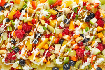 Background of appetizing assorted fruits and berries sprinkled with yogurt