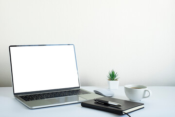 Laptop computer blank screen on white office desk table with coffee cup and notebook, mouse computer with equipment office supplies. Business and finance concept. Workplace, Flat lay with copy space.