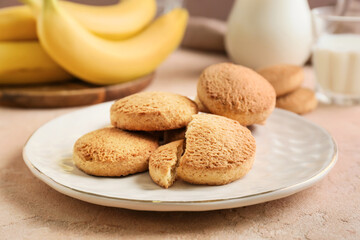 Plate with tasty banana cookies on color background