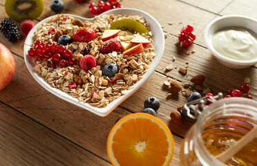 Bowl of muesli near fresh ingredients in morning