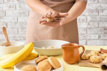 Obraz na płótnie Canvas Woman preparing banana cookies in kitchen