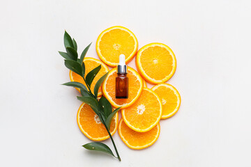 Composition with bottle of orange essential oil on white background