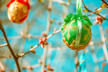 Colorful Easter eggs in brocade cloth hanging from the flower branches, Easter decoration, retro vintage artistic edit