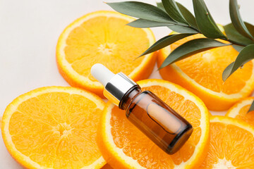 Composition with bottle of orange essential oil on white background