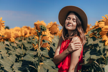 Girl in a field with sunflowers in a hat. Portrait of a woman on the street