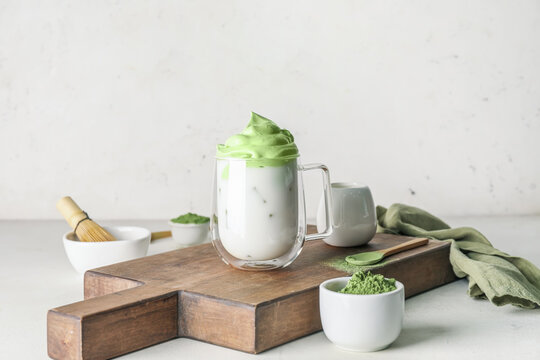 Composition with tasty dalgona matcha latte on light background