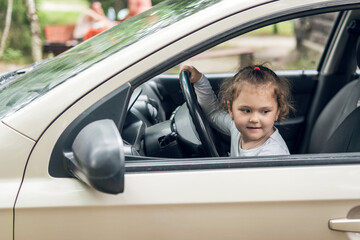 Beautiful cute little girl driving a car