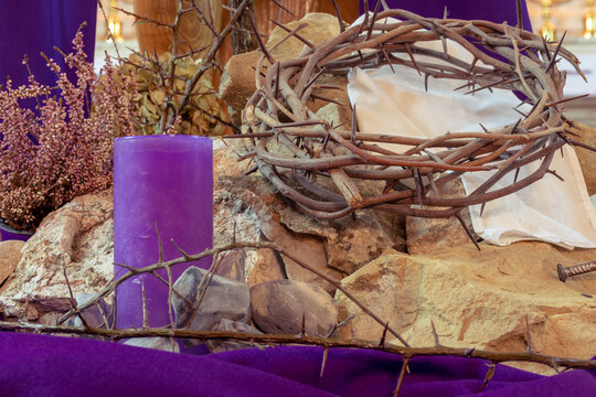 Season of Lent decoration with symbols of the passion of the Christ, crown of thorns, purple cloth and candle, bloody nails and stones, artistic retro vintage edit