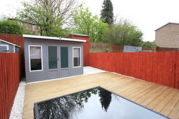 back garden with bespoke hut and wooden decking