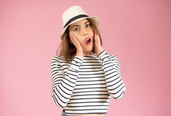 Fototapeta premium Close-up portrait of young pretty surprised woman with opened mouth standing with open palms, isolated over pink background
