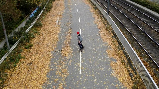 Aerial of a man riding a longboard on an abandoned road , 4k ,drone
