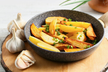 Frying pan of tasty potato with garlic, closeup