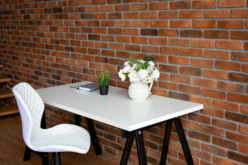 Creative workplace loft brick wall and accessory on white table. copy space, soft selective focus.