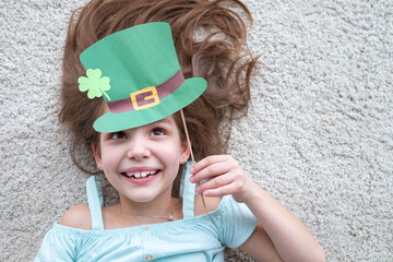 Closeup portrait of a happy preteen caucasian girl in an emerald leprechaun St. Patrick's Day hat
