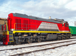 Fototapeta na wymiar Switcher with train of freight cars in line at a rail yard. Small desel manoeuvring locomotive.