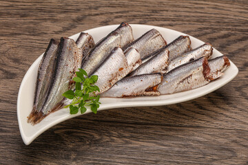 Anchovies in the bowl served basil leaves