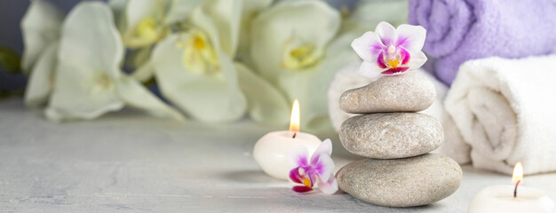 Spa resort therapy composition. Stones, burning candles, towel, abstract lights