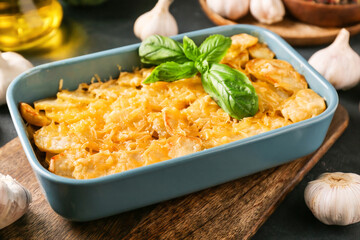 Baking dish of tasty potato with cheese and garlic, closeup