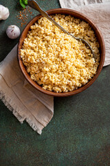Cooked bulgur in a bowl on a dark background top view. Copy space for text. Turkish cuisine, vegan food.