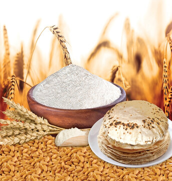 Rustic shot of chapati flatbreads surrounded by ingredients on background of agricultural field
