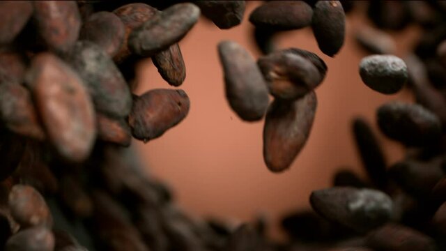 Super slow motion of flying roasted cocoa beans in rotation movement. Filmed on high speed cinema camera, 1000fps.