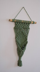 Green macrame hanging on the wall.Macrame model that can be placed in a flower pot.