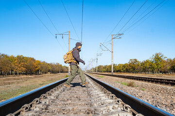 Male traveler with tactical and militari equipment walk alone in sunny day