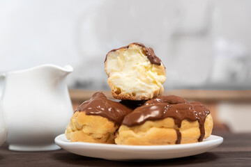 Cut eclair with cream poured with chocolate, close-up. Sweet dessert