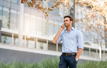 Businessman talking on his phone while standing outside of his office