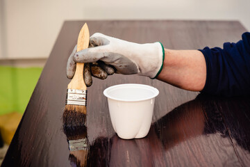 Aplicando barniz a una mesa de madera vieja