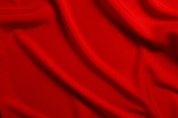 Red silk or satin luxury fabric texture can use as abstract background. Top view.