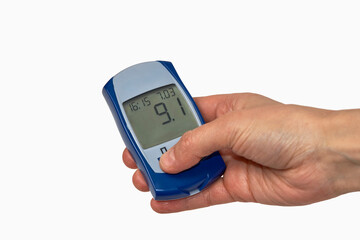 Hand holding glucometer with blood sugar test result.