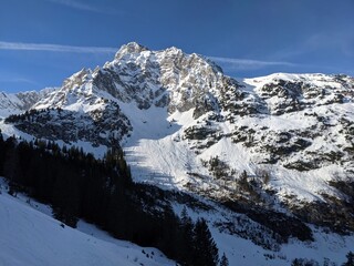 snowy mountain in switzerland shines through the first rays of sunshine