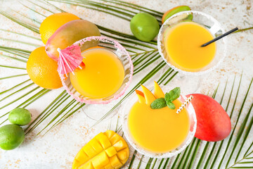 Glasses of mango margarita on light background