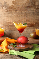 Glass of margarita with mango on wooden background