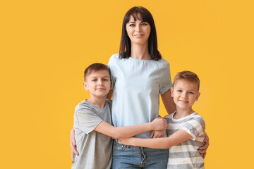 Happy mother and cute children on color background