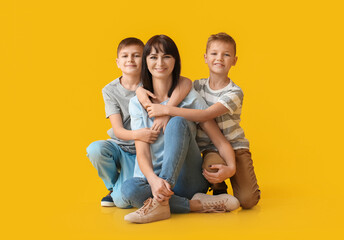 Happy mother and cute children on color background